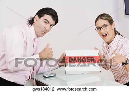 Portrait of a businesswoman and a businessman holding a box View Large Photo Image Stock Image - Portrait of a businesswoman and a businessman holding a box. Fotosearch