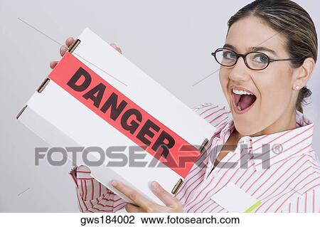 Stock Image - Portrait of a businesswoman holding a package. Fotosearch