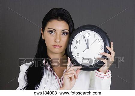 Portrait of a businesswoman holding a clock View Large Photo Image Stock Photo - Portrait of a businesswoman holding a clock. Fotosearch