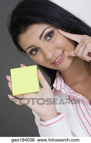 Portrait of a businesswoman holding a blank adhesive note and smiling View Large Photo Image Stock Photo - Portrait of a businesswoman holding a blank adhesive note and smiling. Fotosearch