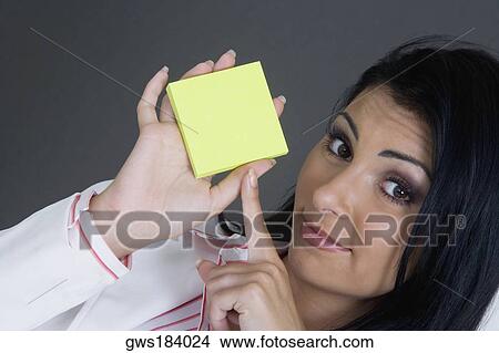 Portrait of a businesswoman pointing towards a blank adhesive note View Large Photo Image Picture - Portrait of a businesswoman pointing towards a blank adhesive note. Fotosearch