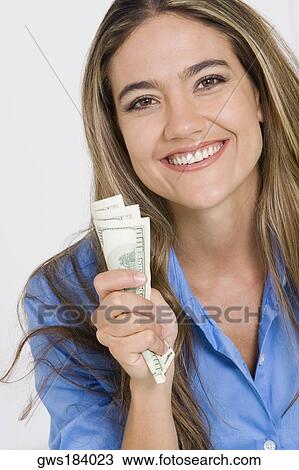 Portrait of a young woman holding American paper currency and smiling View Large Photo Image Stock Image - Portrait of a young woman holding American paper currency and smiling. Fotosearch