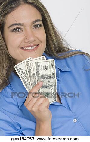 Portrait of a young woman holding American paper currency and smiling View Large Photo Image Stock Image - Portrait of a young woman holding American paper currency and smiling. Fotosearch