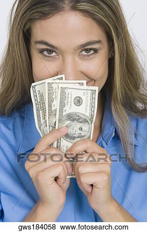 Portrait of a young woman holding American paper currency View Large Photo Image Stock Photo - Portrait of a young woman holding American paper currency. Fotosearch