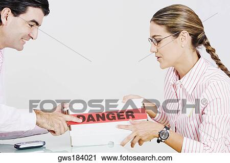 Side profile of a businessman and a businesswoman holding a package View Large Photo Image Stock Image - Side profile of a businessman and a businesswoman holding a package. Fotosearch