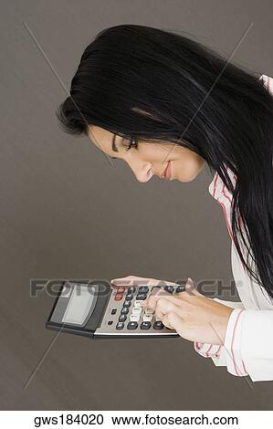 Side profile of a businesswoman holding a calculator View Large Photo Image Stock Image - Side profile of a businesswoman holding a calculator. Fotosearch