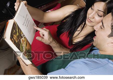 Close-up of a couple reading a cookbook in the kitchen View Large Photo Image Stock Photo - Close-up of a couple reading a cookbook in the kitchen. Fotosearch