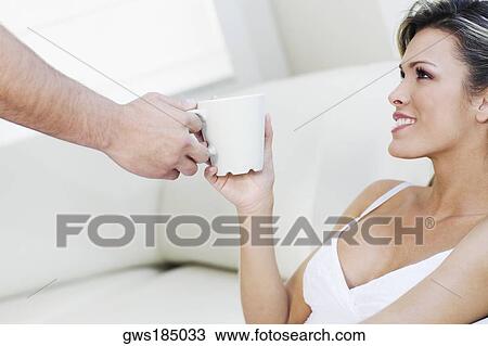 Close-up of a man's hand giving a tea cup to a young woman View Large Photo Image Stock Image - Close-up of a man's hand giving a tea cup to a young woman. Fotosearch