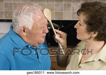 Close-up of a senior woman hitting a senior man with a ladle View Large Photo Image Stock Image - Close-up of a senior woman hitting a senior man with a ladle. Fotosearch