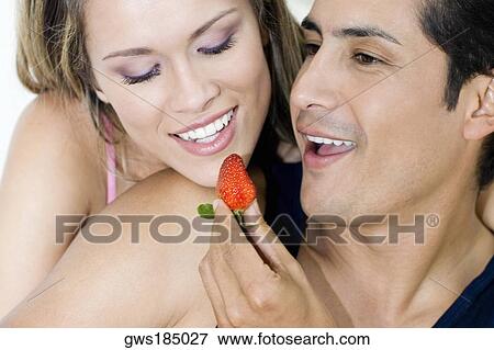 Close-up of a young man feeding a strawberry to a young woman View Large Photo Image Stock Photo - Close-up of a young man feeding a strawberry to a young woman. Fotosearch