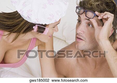 Stock Image - Close-up of a young woman and a mid adult man looking at each other. Fotosearch