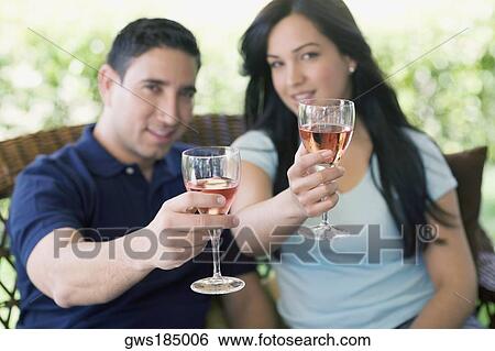Portrait of a mid adult man and a young woman holding wine glasses View Large Photo Image Stock Photograph - Portrait of a mid adult man and a young woman holding wine glasses. Fotosearch