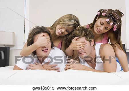 Two young women covering eyes of their boyfriends View Large Photo Image Stock Photography - Two young women covering eyes of their boyfriends. Fotosearch