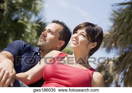 Close-up of a mid adult couple sitting together and looking away View Large Photo Image Stock Photography - Close-up of a mid adult couple sitting together and looking away. Fotosearch