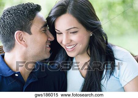 Close-up of a mid adult man whispering into a young woman's ear View Large Photo Image Stock Photography - Close-up of a mid adult man whispering into a young woman's ear. Fotosearch