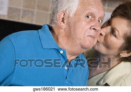Stock Image - Close-up of a senior woman kissing a senior man. Fotosearch