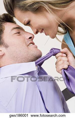 Close-up of a young woman pulling a mid adult man towards her with his tie View Large Photo Image Stock Image - Close-up of a young woman pulling a mid adult man towards her with his tie. Fotosearch