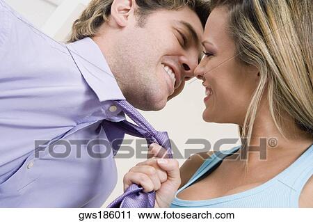 Close-up of a young woman pulling a mid adult man towards her with his tie View Large Photo Image Stock Image - Close-up of a young woman pulling a mid adult man towards her with his tie. Fotosearch
