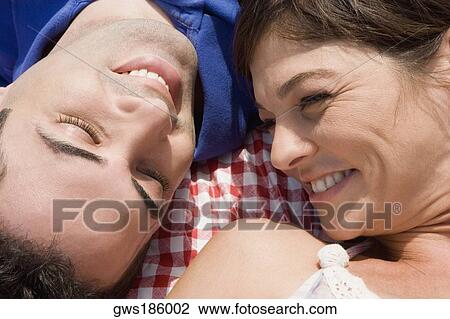 High angle view of a mid adult couple lying on a picnic blanket and smiling View Large Photo Image Stock Image - High angle view of a mid adult couple lying on a picnic blanket and smiling. Fotosearch