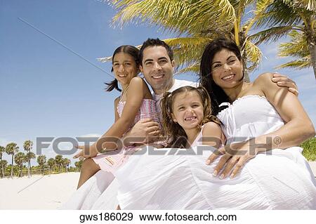 Mid adult couple with their two daughters on the beach View Large Photo Image Stock Photo - Mid adult couple with their two daughters on the beach. Fotosearch