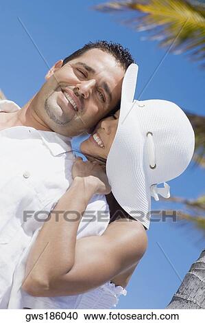 Stock Image - Mid adult woman embracing a mid adult man from behind. Fotosearch