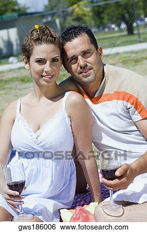 Portrait of a mid adult couple holding glasses of wine View Large Photo Image Stock Photograph - Portrait of a mid adult couple holding glasses of wine. Fotosearch