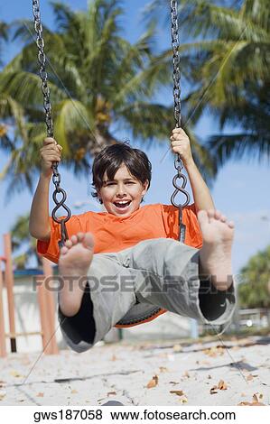 Boy swinging on a swing View Large Photo Image Stock Photo - Boy swinging on a swing. Fotosearch