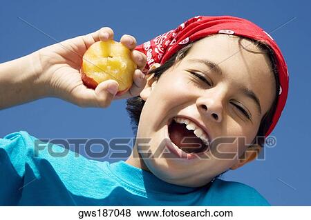Close-up of a boy holding an apple and smiling View Large Photo Image Stock Photo - Close-up of a boy holding an apple and smiling. Fotosearch