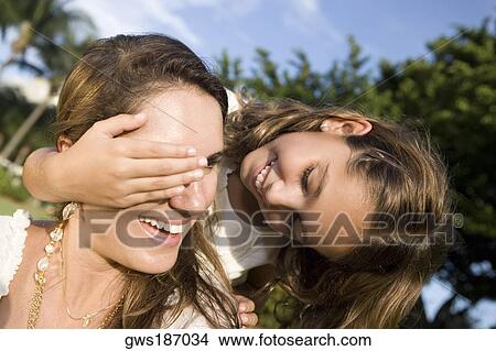 Close-up of a girl covering her mother's eyes View Large Photo Image Picture - Close-up of a girl covering her mother's eyes. Fotosearch