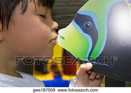 Close-up of a girl kissing a fish toy View Large Photo Image Stock Photo - Close-up of a girl kissing a fish toy. Fotosearch