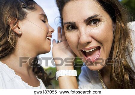 Close-up of a girl whispering into her mother's ear View Large Photo Image Stock Photography - Close-up of a girl whispering into her mother's ear. Fotosearch