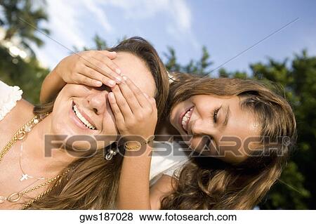 Girl covering her mother's eyes View Large Photo Image Stock Photo - Girl covering her mother's eyes. Fotosearch