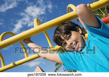 Portrait of a boy hanging on monkey bars and smiling View Large Photo Image Stock Photo - Portrait of a boy hanging on monkey bars and smiling. Fotosearch
