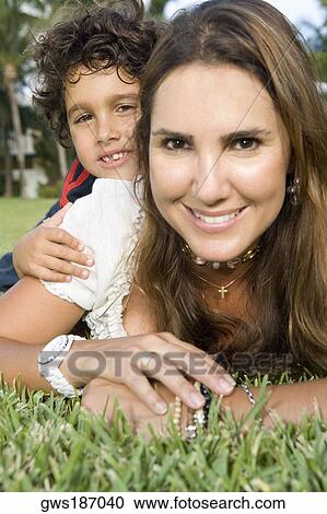 Portrait of a boy lying on the back of his mother View Large Photo Image Stock Image - Portrait of a boy lying on the back of his mother. Fotosearch