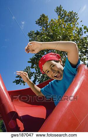 Portrait of a boy sliding on a slide View Large Photo Image Stock Photo - Portrait of a boy sliding on a slide. Fotosearch