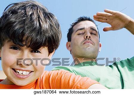 Portrait of a boy smiling with his father behind him View Large Photo Image Picture - Portrait of a boy smiling with his father behind him. Fotosearch