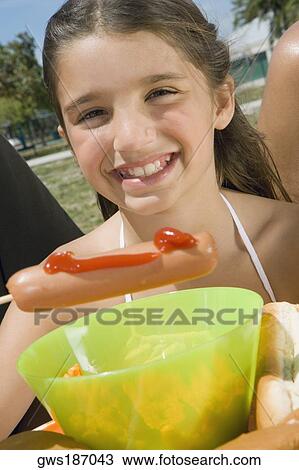 Portrait of a girl holding a sausage and smiling View Large Photo Image Stock Image - Portrait of a girl holding a sausage and smiling. Fotosearch