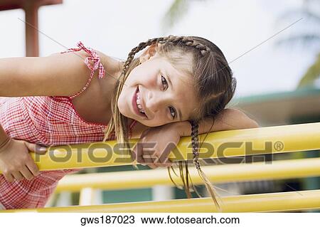Stock Image - Portrait of a girl on a jungle gym and smiling. Fotosearch