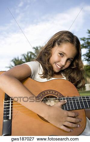 Portrait of a girl playing a guitar View Large Photo Image Stock Photo - Portrait of a girl playing a guitar. Fotosearch