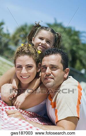 Portrait of a mid adult couple with their daughter lying on a picnic blanket View Large Photo Image Stock Image - Portrait of a mid adult couple with their daughter lying on a picnic blanket. Fotosearch