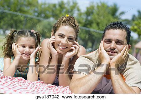 Portrait of a mid adult couple with their daughter lying on a picnic blanket View Large Photo Image Stock Image - Portrait of a mid adult couple with their daughter lying on a picnic blanket. Fotosearch