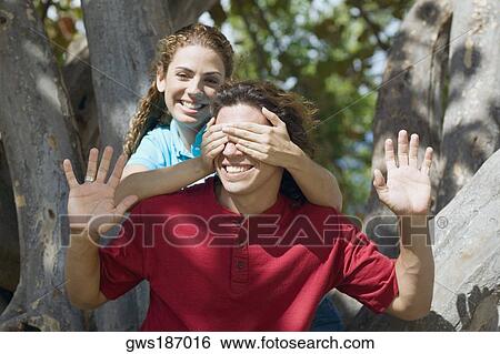 Portrait of a mid adult woman covering a mid adult man's eyes from behind View Large Photo Image Stock Photograph - Portrait of a mid adult woman covering a mid adult man's eyes from behind. Fotosearch