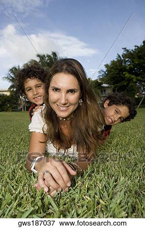 Portrait of a mid adult woman lying on grass with her two children View Large Photo Image Stock Photo - Portrait of a mid adult woman lying on grass with her two children. Fotosearch