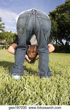 Rear view of a boy looking through his legs View Large Photo Image Stock Image - Rear view of a boy looking through his legs. Fotosearch