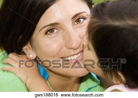Stock Photograph - Close-up of a girl kissing her mother. Fotosearch