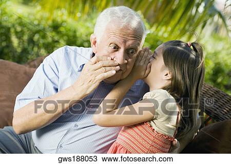 Close-up of a girl whispering into her grandfather's ear View Large Photo Image Stock Image - Close-up of a girl whispering into her grandfather's ear. Fotosearch