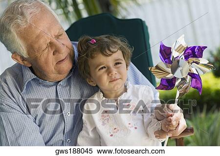 Girl and her grandfather playing with a pinwheel View Large Photo Image Stock Photography - Girl and her grandfather playing with a pinwheel. Fotosearch