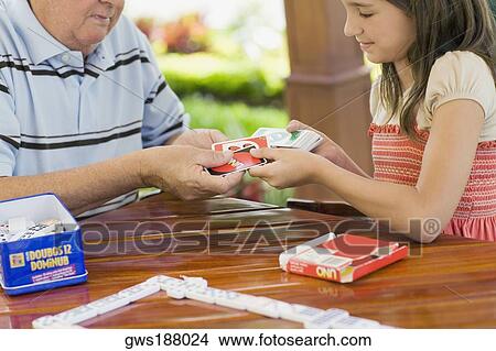 Girl playing cards with her grandfather View Large Photo Image Picture - Girl playing cards with her grandfather. Fotosearch