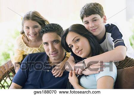 Portrait of a couple smiling with their two children View Large Photo Image Stock Image - Portrait of a couple smiling with their two children. Fotosearch