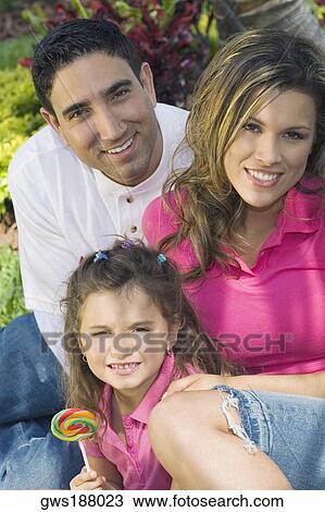 Portrait of a mid adult man and a young woman smiling with a girl View Large Photo Image Stock Image - Portrait of a mid adult man and a young woman smiling with a girl. Fotosearch